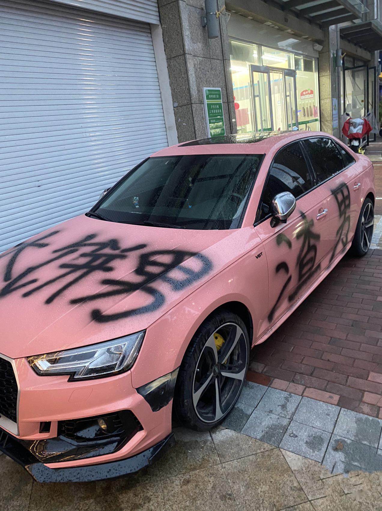 一辆粉红色的奥迪小汽车,被人喷上了大饼男,渣男字样