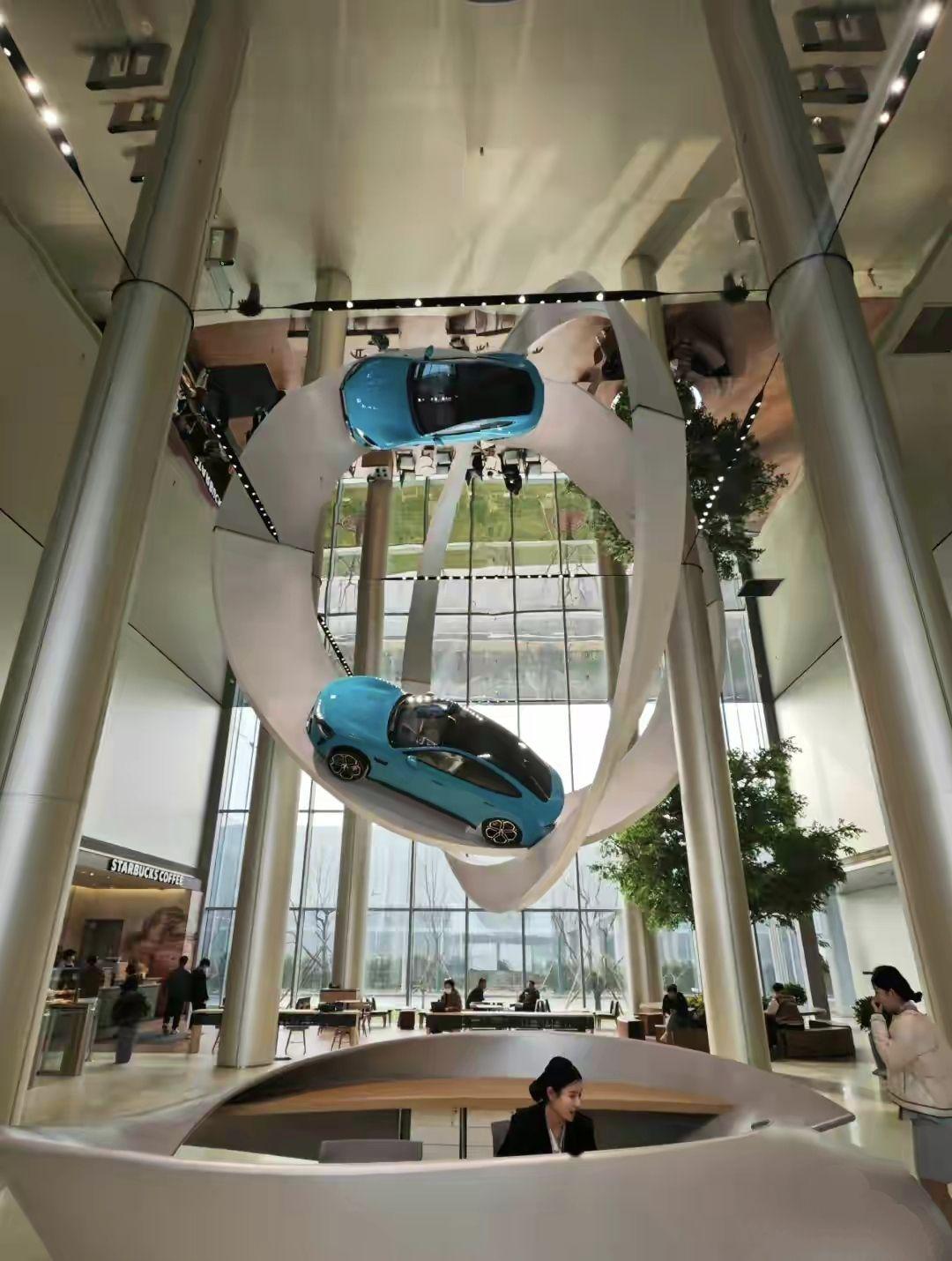 小米的汽车总部设计都是超级fashion的,两台跑车挂在空中跑道上,这